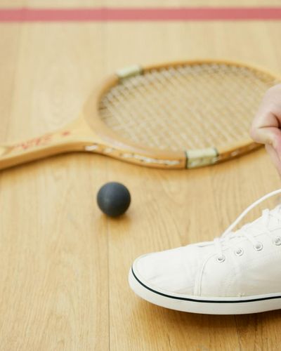 Close-up of athletic shoes on a wooden floor, ready for exercise.